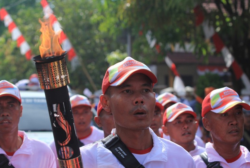 Sejumlah pasukan membawa obor saat kirab Api PON yang diambil dari sumber api alam di Indramayu, Jawa Barat, Senin (5/9). 
