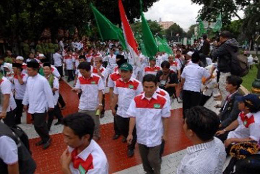 Sejumlah pasukan paskibraka membawa bendera Merah Putih dan bendera tarekat NU saat merayakan acara puncak kirab resolusi jihad Nahdlatul Ulama (NU) di Tugu Proklamasi, Jakarta, Jumat (25/11). 