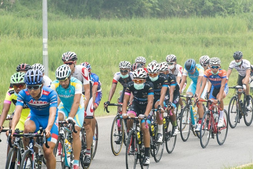 Sejumlah pebalap sepeda menggunakan masker saat beradu kecepatan pada Tour De Singkarak Etape Keenam di Malalak, Sumatera Barat, Kamis (8/10). 