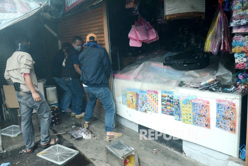 Sejumlah pedagang berusaha membongkar kios untuk menyelamatkan barang-barangnya saat peristiwa kebakaran di Pasar Kosambi, Kota Bandung, Ahad (19/5).