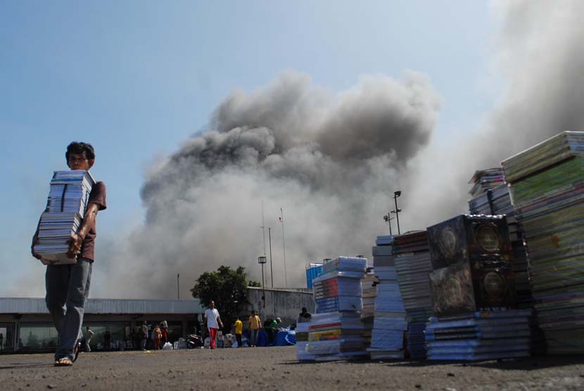 Sejumlah pedagang berusaha untuk memindahkan barang dagangannya dari lalapan api yang membakar gedung Pasar Senen, Jakarta Pusat, Jumat (25/4).