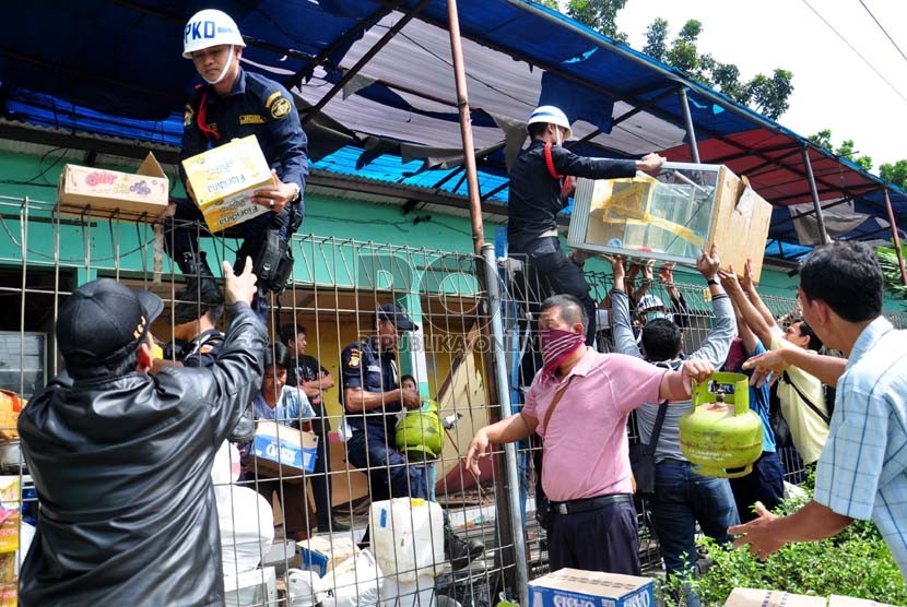  Sejumlah pedagang kaki lima (PKL) dibantu petugas mengangkut barang mereka saat penertiban PKL di Stasiun Pasar Minggu, Kamis (18/4). (Republika/Rakhmawaty La'lang)