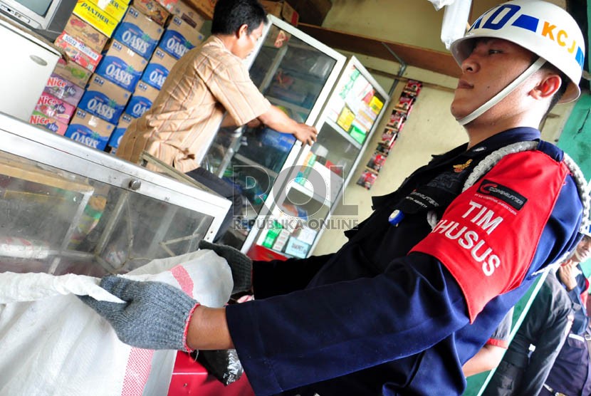  Sejumlah pedagang kaki lima (PKL) dibantu petugas mengangkut barang mereka saat penertiban PKL di Stasiun Pasar Minggu, Kamis (18/4). Stasiun UI, Depok, Rabu (29/5/2013) juga melakukan penertiban untuk mensterilkan kegiatan non-KAI di kawasan tersebut.