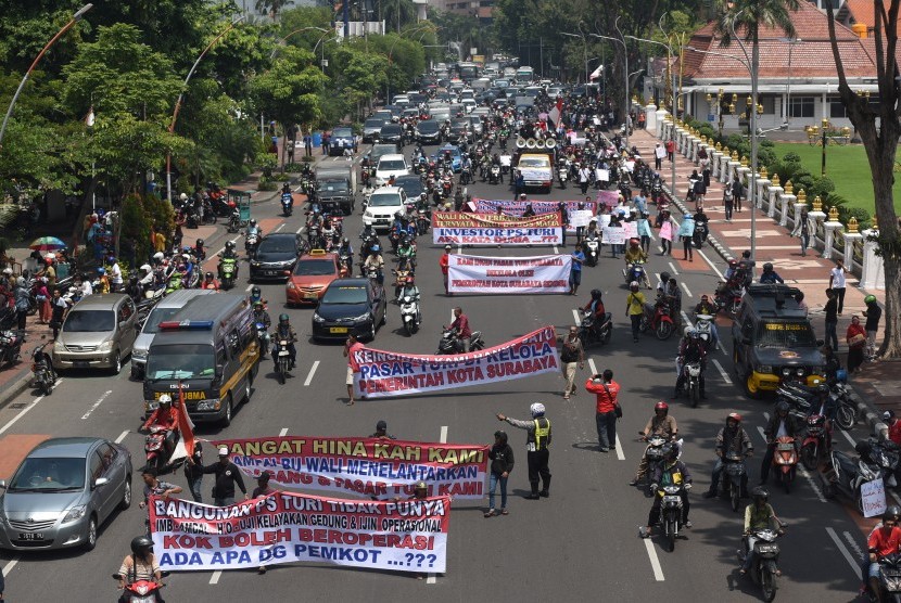 Sejumlah pedagang lama Pasar Turi membentangkan spanduk dan poster saat berunjuk rasa di Surabaya, Jawa Timur, Rabu (16/3).