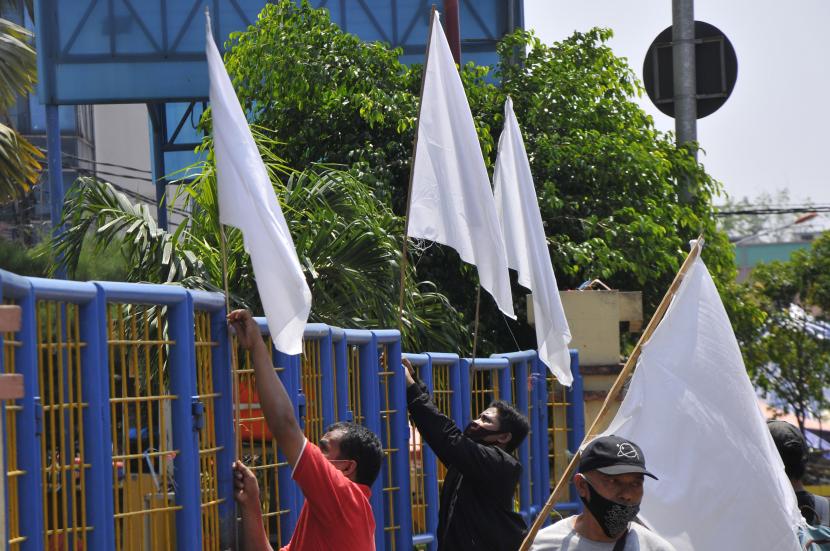 Sejumlah pedagang melakukan aksi mengibarkan bendera putih di depan pusat perbelanjaan Sentra Grosir Cikarang (SGC) di Kabupaten Bekasi, Jawa Barat, Rabu (11/8/2021). Aksi tersebut sebagai protes penutupan pertokoan selama PPKM