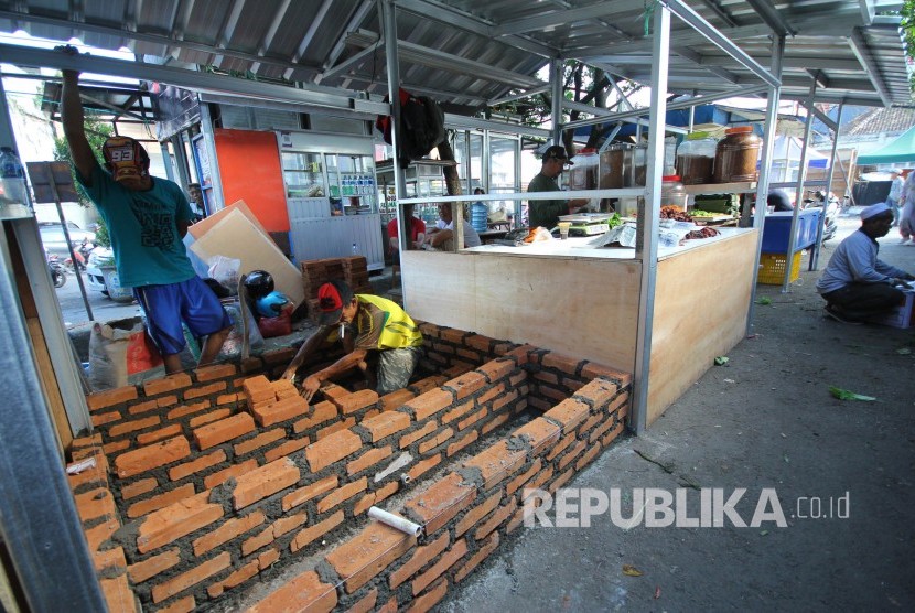 Sejumlah pedagang membangun kios di halaman parkir Pasar Kosambi, Kota Bandung, Selasa (11/6).