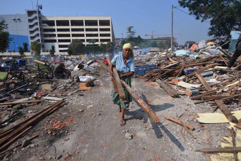 Sejumlah pedagang mengumpulkan kembali sisa puing bangunan yang layak di tengah bongkaran kios kawasan Terminal Depok, Jawa Barat, Kamis (9/10).(Republika/Rakhmawaty La'lang)