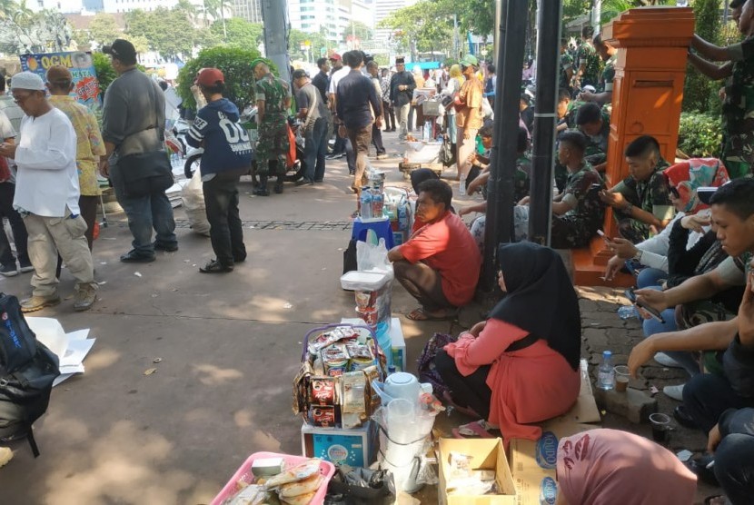 Sejumlah pedagang menjajakan dagangannya di tengah masa aksi di sekitar patung kuda Jalan Medan Merdeka Barat (ilustrasi).
