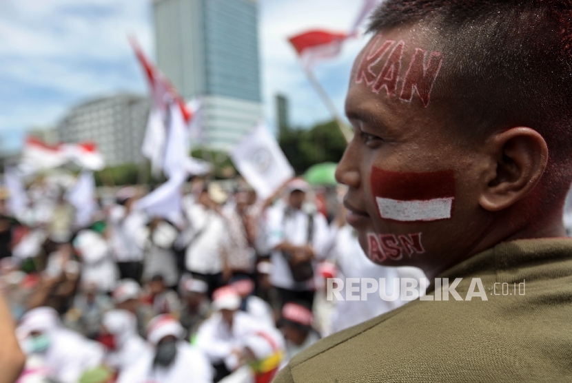 Sejumlah pegawai honorer pemerintah, pegawai tetap non-PNS dan pegawai kontrak di pemerintahan yang tergabung dalam Komite Nasional Revisi UU Aparatur Sipil Negara (ASN) melakukan aksi damai di depan Kompleks Parlemen, Senaya, Jakarta, Kamis (15/12).