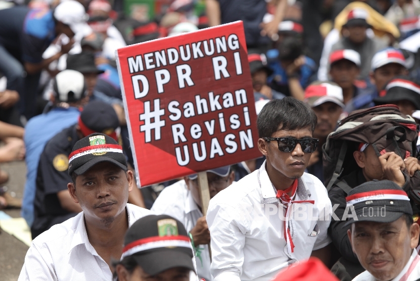 Sejumlah pegawai honorer pemerintah, pegawai tetap non-PNS dan pegawai kontrak di pemerintahan yang tergabung dalam Komite Nasional Revisi UU Aparatur Sipil Negara (ASN) melakukan aksi damai di depan Kompleks Parlemen, Senaya, Jakarta, Kamis (15/12).