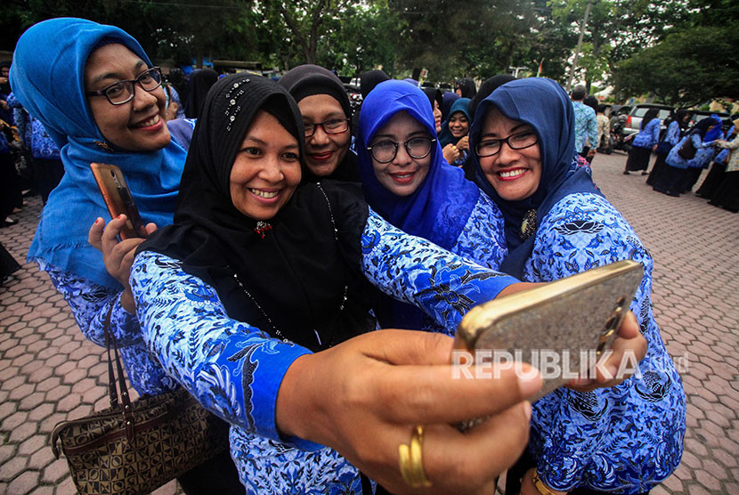 Sejumlah Pegawai Negeri Sipil (PNS) berfoto dan halal bihalal usai mengikuti apel gabungan hari pertama masuk kantor setelah cuti bersama Idul Fitri 1439 Hijriah di Aceh Utara, Aceh, Kamis (21/6).