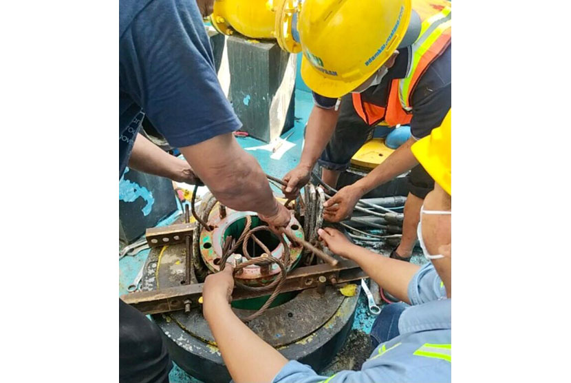 Sejumlah pegawai Perumda Air Minum Tugu Tirta Kota Malang memperbaiki pompa transmisi yang rusak di Sumber Wendit. 