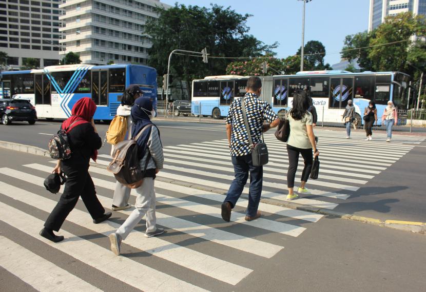Sejumlah pejalan kaki menyeberang di pelican cross di Kawasan Bundaran Hotel Indonesia, Jakarta. Status Pemberlakuan Pembatasan Kegiatan Masyarakat (PPKM) di DKI Jakarta dan sekitarnya kembali masuk level satu mulai Rabu ini (6/7/2022) setelah sehari sebelumnya, Selasa (5/7) masuk level dua.