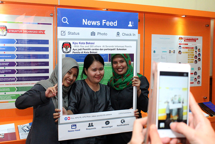 (Ilustrasi) Sejumlah pekerja berpose dengan latar depan miniatur sosialisasi pemilu melalui media sosial usai peluncuran Serambi Informasi Pemilu di Kantor Komisi Pemilihan Umum (KPU) Kota Bekasi, Bekasi, Jawa Barat, Jumat (31/3).