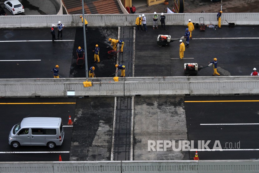 Sejumlah pekerja melakukan pengerjaan perbaikan sisi sambung jalan Tol layang Jakarta-Cikampek II (Elevated), di Bekasi, Jawa Barat, Rabu (11/12/2019).
