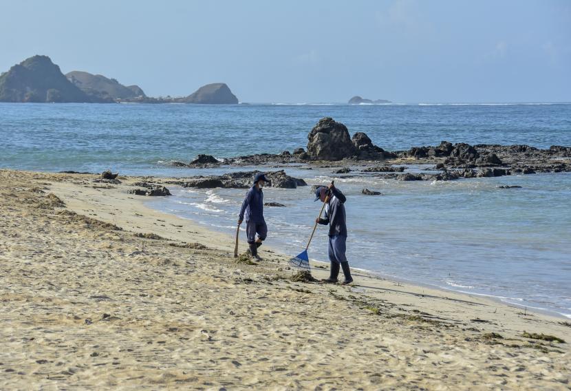 Sejumlah pekerja membersihkan sampah di pinggiran Pantai Kuta Kawasan Ekonomi Khusus (KEK) Mandalika, Kecamatan Pujut, Praya, Lombok Tengah, NTB (ilustrasi)