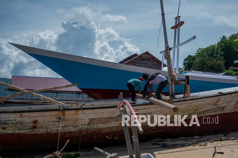 Sejumlah pekerja membongkar bagian-bagian kapal yang akan direparasi di Galangan Kapal Rakyat (GKR) Donggala, Sulawesi Tengah, Selasa (1/2/2022). BKI berkomitmen meningkatkan kualitas industri pelayaran dan galangan kapal nasional. 