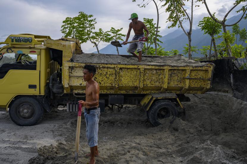 Sejumlah pekerja membongkar muat pasir ke atas truk di kawasan pertambangan pasir. ilustrasi
