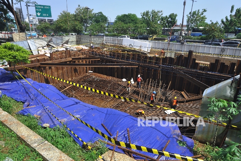 Sejumlah pekerja membongkar rangka yang akan dijadikan tiang penyangga pada proyek Light Rapid Transit (LRT) yang amblas di depan Menara Saidah, Jalan MT Haryono, Jakarta, Jumat (13/10).