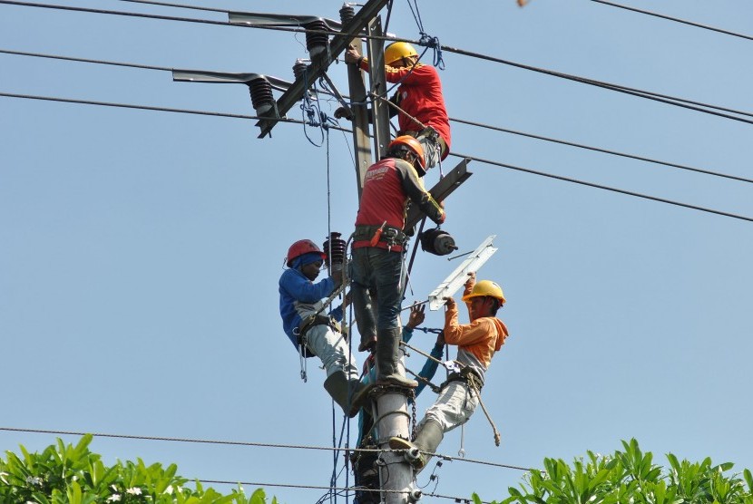 Sejumlah pekerja memperbaiki instalasi jaringan listrik di pinggir jalan kota Magelang, Jateng, Senin (13/6). 