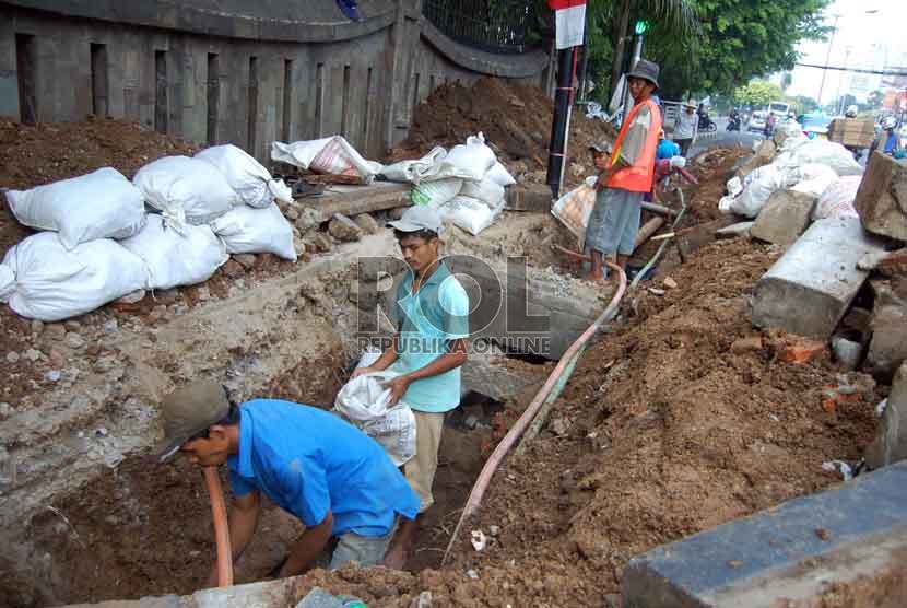  Sejumlah pekerja memperbaiki saluran air di kawasan Menteng, Jakarta Pusat, Jumat (15/8). (Republika/Raisan Al Farisi)