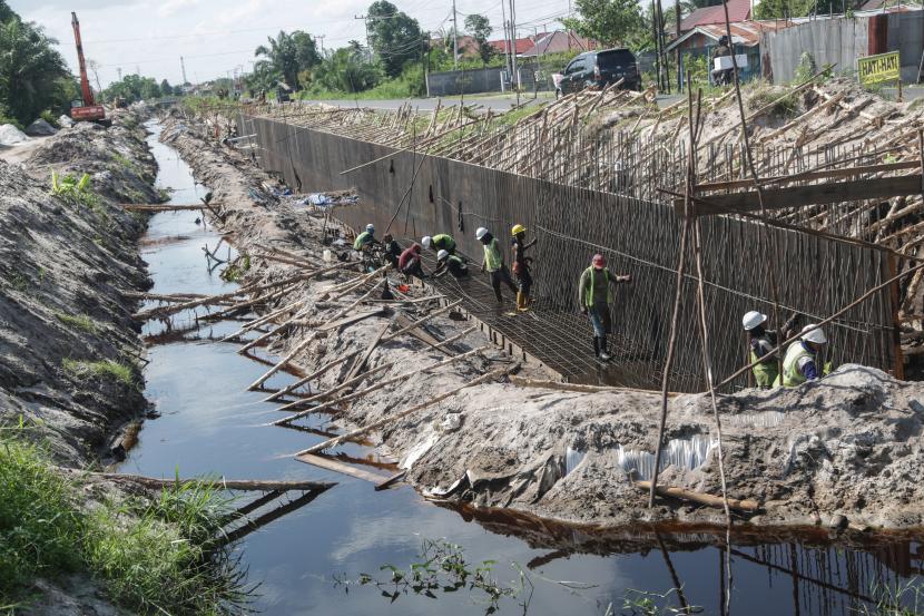 Sejumlah pekerja memperbaiki saluran drainase di kawasan Jalan Tingang, Palangkaraya, Kalimantan Tengah, Kamis (7/4/2022). Pemerintah Kota Palangka Raya, Provinsi Kalimantan Tengah, menetapkan status siaga darurat bencana banjir.