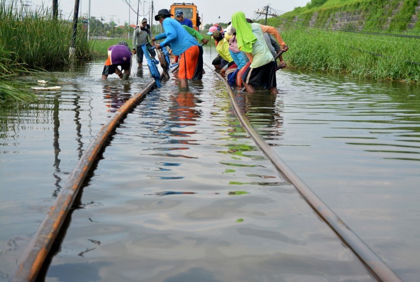 Sejumlah pekerja mengerjakan perbaikan bantaran rel kereta api yang terendam di kawasan Porong, Sidoarjo, Jawa Timur, Rabu (17/2).
