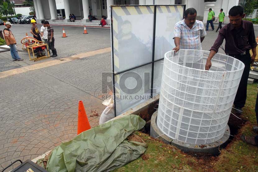 Sejumlah pekerja mengerjakan proyek sumur resapan di halaman depan Balai Kota, Jakarta, Senin (22/1).   (Republika/Agung Fatma Putra)