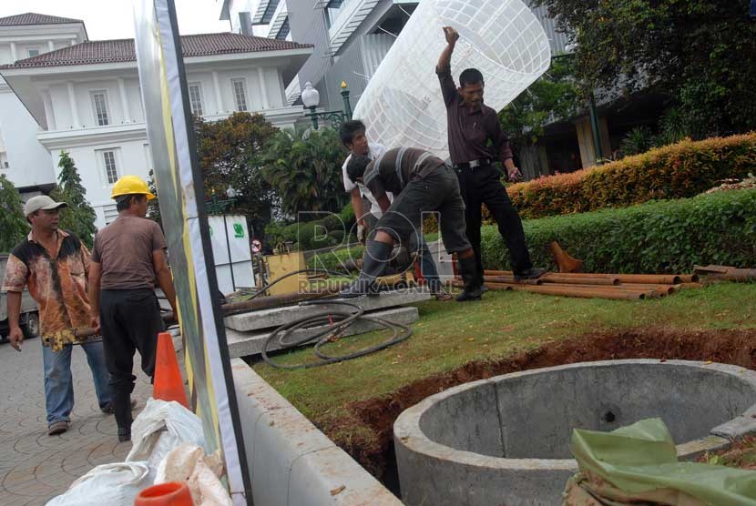 Sejumlah pekerja mengerjakan proyek sumur resapan di halaman depan Balai Kota, Jakarta, Senin (22/1).   (Republika/Agung Fatma Putra)