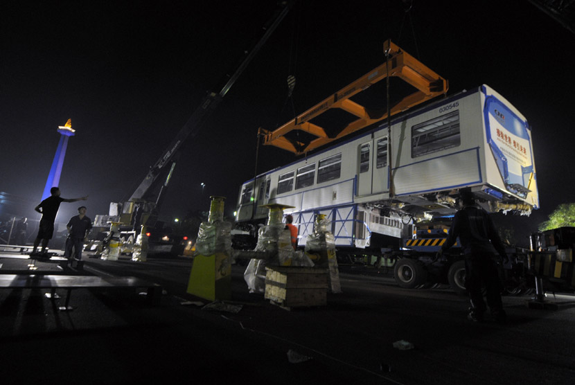  Sejumlah pekerja menurunkan gerbong monorail di halaman Lapangan Monas, Jakarta, Sabtu (8/6) dini hari.  (Antara/Zabur Karuru)