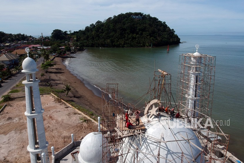 Sejumlah pekerja menyelesaikan pembangunan kubah masjid, di Pantai Padang, Sumatera Barat, Ahad (9/12/2018).