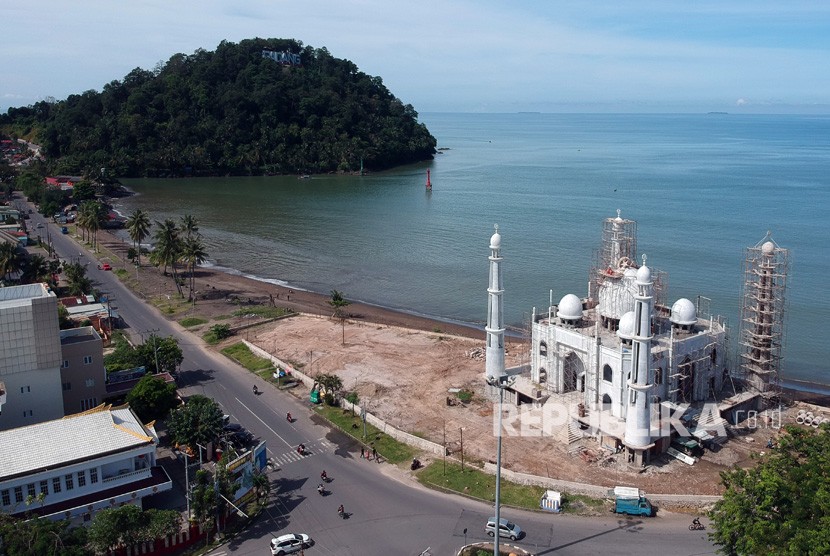 Sejumlah pekerja menyelesaikan pembangunan kubah masjid, di Pantai Padang, Sumatera Barat, Minggu (9/12/2018). 