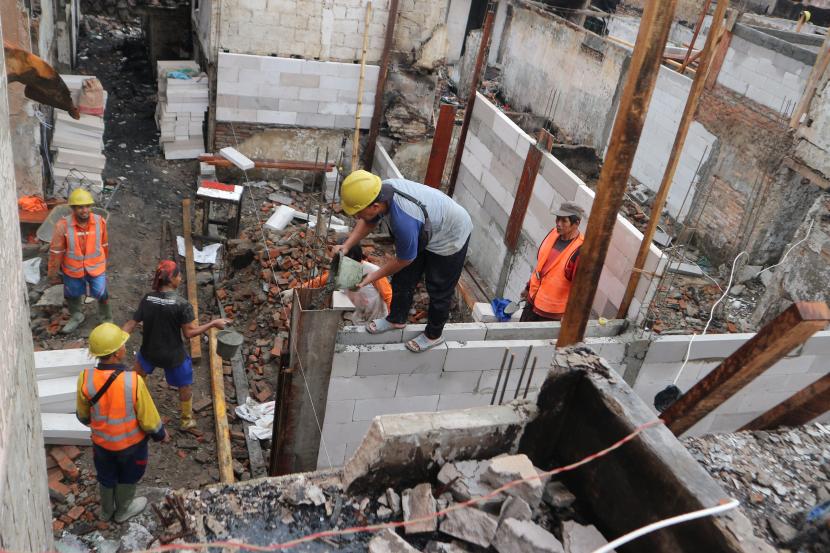Sejumlah pekerja menyelesaikan pembangunan rumah di lokasi bekas kebakaran Pasar Gembrong, Kelurahan Cipinang Besar Utara, Jakarta Timur, Sabtu (16/7/2022). 