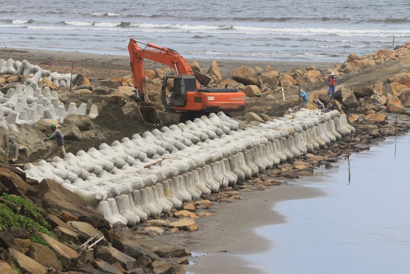 Sejumlah pekerja menyelesaikan pembangunan tanggul laut dan pemasangan batu pemecah ombak di kawasan pantai Desa Suak Timah, Samatiga, Aceh Barat, Aceh, Ahad (10/3/2019).