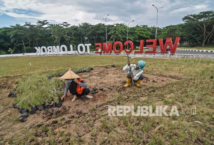 Sejumlah pekerja menyelesaikan penanaman rumput di taman bundaran Bandara Internasional Lombok (BIL) di Praya, Lombok Tengah, NTB, Senin (7/2/2022). Dinas Perdagangan Provinsi Nusa Tenggara Barat menyiapkan setidaknya 12 spot UMKM untuk menyambut perhelatan MotoGP di Sirkuit Mandalika pada 18-20 Maret 2022 mendatang.
