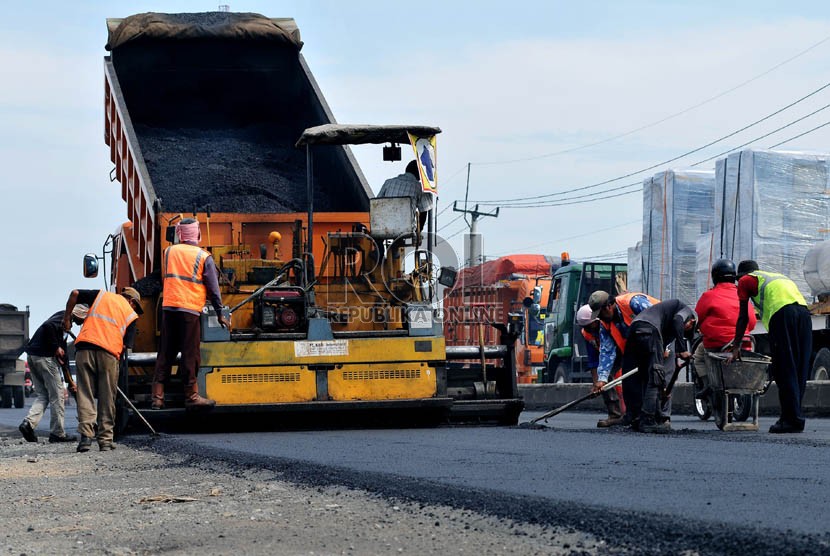   Sejumlah pekerja menyelesaikan perbaikan jalan di jalur pantura wilayah Indramayu, Jawa Barat.