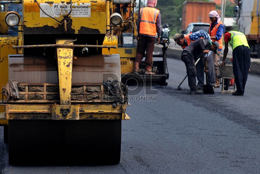   Sejumlah pekerja menyelesaikan perbaikan jalan di jalur pantura wilayah Indramayu, Jawa Barat, Ahad (28/7). (Republika/Prayogi)
