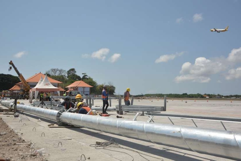 Sejumlah pekerja menyelesaikan proyek perluasan apron Bandara Internasional I Gusti Ngurah Rai, Bali, Selasa (18/9). 