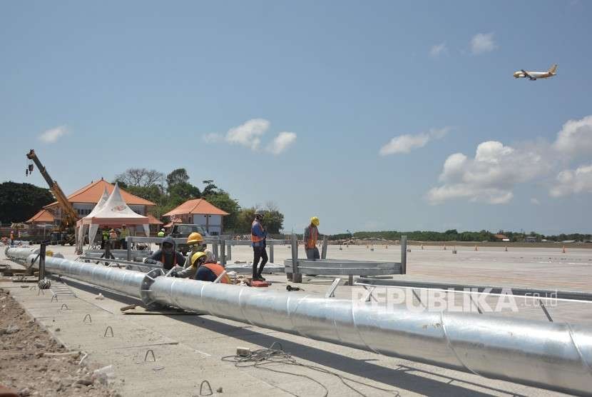 Sejumlah pekerja menyelesaikan proyek perluasan apron Bandara Internasional I Gusti Ngurah Rai, Bali, Selasa (18/9).