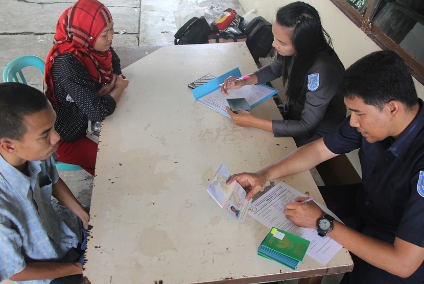Sejumlah pekerja migran yang dideportasi dari Malaysia diperiksa oleh petugas Pos Pelayanan Penempatan dan Perlindungan Tenaga Kerja Indonesia (P4TKI) Dumai di kota Dumai, Riau, Selasa (12/3/2019).