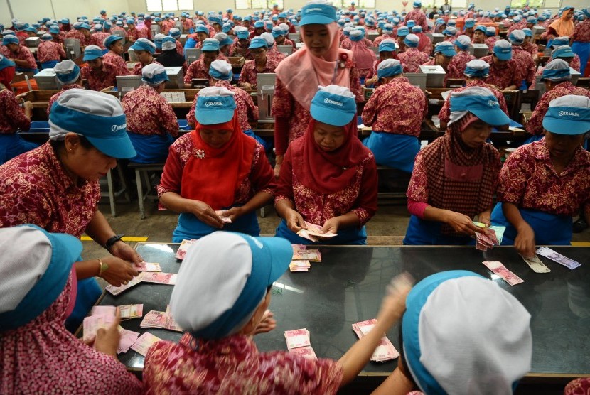 Sejumlah pekerja pabrik rokok menerima uang Tunjangan Hari Raya (THR) Lebaran di Kudus, Jawa Tengah, Kamis (15/6). 