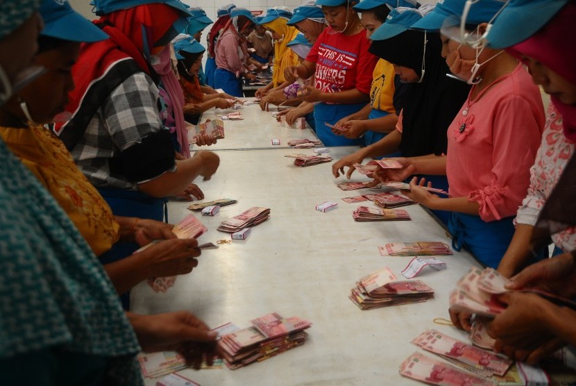 Sejumlah pekerja pabrik rokok menghitung uang Tunjangan Hari Raya (THR) Lebaran 