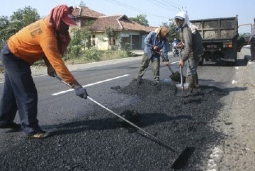 Sejumlah pekerja perbaikan jalan di Jalur Pantura, menjelang mudik lebaran 2011.
