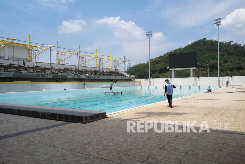 Sejumlah pekerja sedang melakukan aktifitas pembangunan dan pembersihan kolam di lokasi venue polo air di area Stadion Si Jalak Harupat, Kutawaringin, Kabupaten Bandung, Senin (5/9). (Republika/ Umar Mukhtar) 