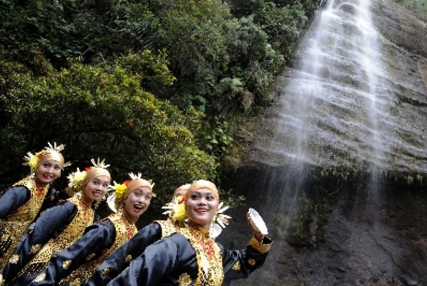 Sejumlah pelajar berlatih tari piring sesaat sebelum tampil pentas di kawasan air terjun Lembah Harau, Lima Puluh Koto, Sumatera Barat, Kamis (9/6). Obyek wisata yang menawarkan panorama alam berupa tebing tinggi, hutan, dan air terjun itu merupakan tempat