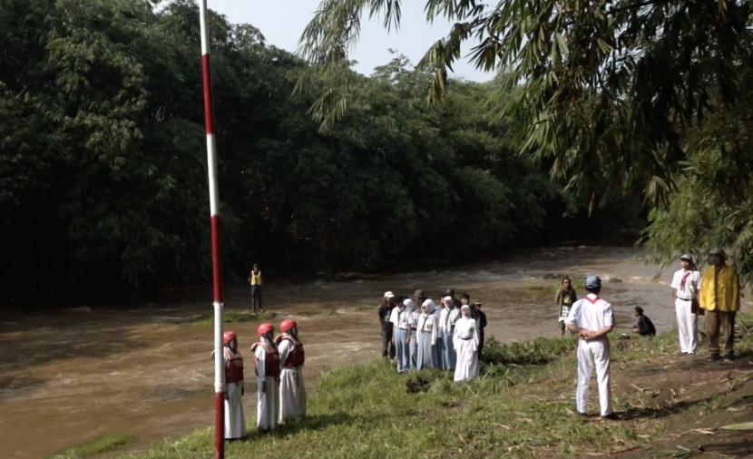 Sejumlah pelajar bersama Komunitas Ciliwung Depok menggelar upacara HUT RI ke-77 di bantaran sungai Ciliwung.