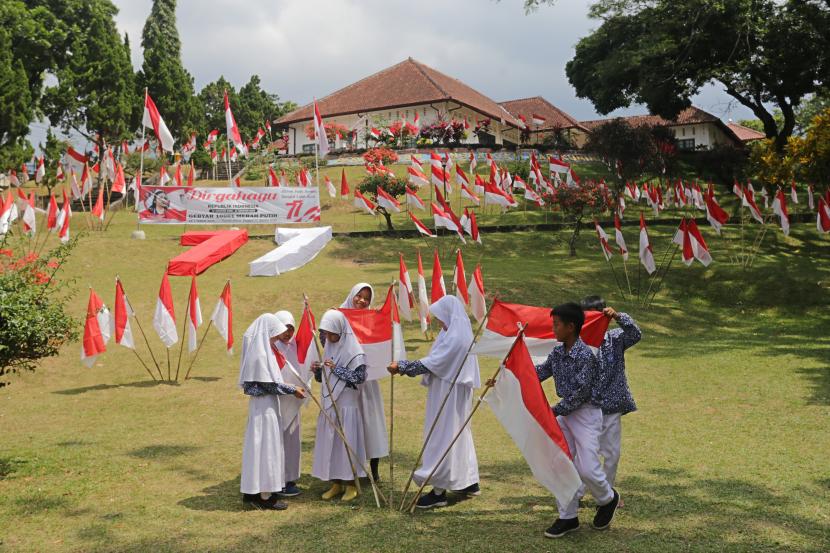 Sejumlah pelajar memasang Bendera Merah Putih di halaman Gedung Perundingan Linggarjati, Kuningan, Jawa Barat, Kamis (11/8/2022). Pemasangan 10.001 Bendera Merah Putih tersebut dalam rangka menyambut perayaan HUT ke-77 Kemerdekaan RI. 