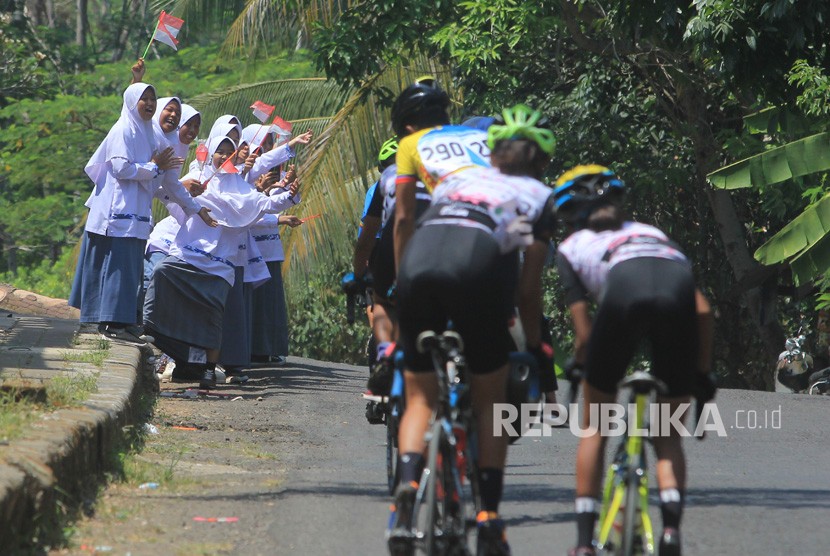 Sejumlah pelajar memberi semangat kepada pebalap saat mengikuti kategori Individual Time Trial pada International Tour de Linggarjati 2019 di Mandirancan, Kuningan, Jawa Barat, Jumat (13/9/2019).