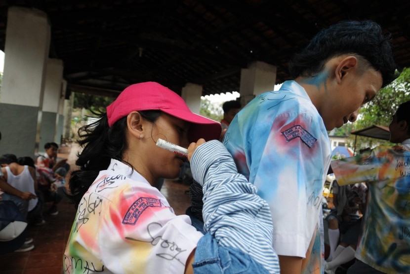Sejumlah pelajar mencorat-coret baju seragam sekolah mereka seusai mengikuti Ujian Nasional tingkat SMK di Depok, Jawa Barat, Kamis (7/4). 