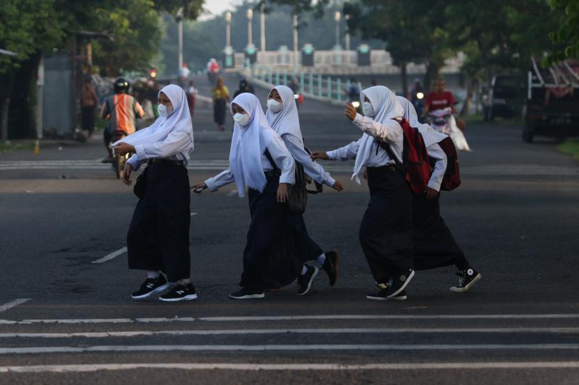 Sejumlah pelajar menyeberang jalan menuju ke sekolah di kawasan Platuk Donomulyo, Surabaya, Jawa Timur (ilustrasi).